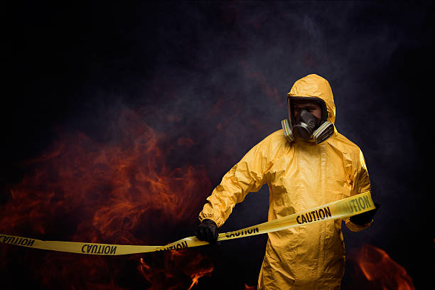Caution Man in protective workwear with Caution cordon tape biochemical weapon photos stock pictures, royalty-free photos & images
