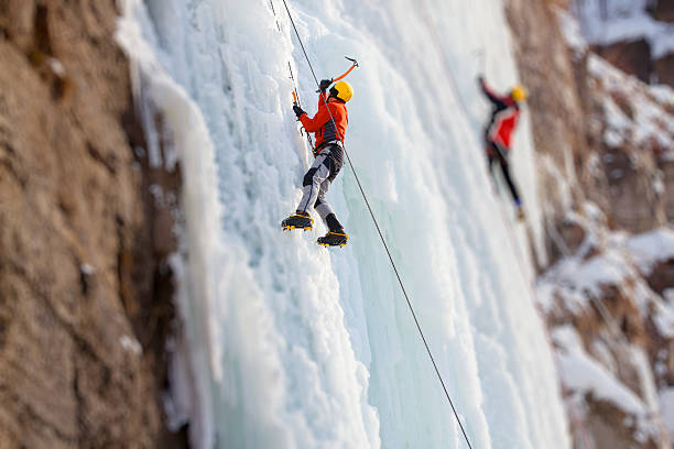 istock Man climbing frozen waterfall 614705450