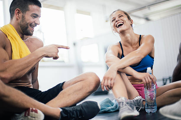 Smiling young athletes refreshing after training Happy young couple resting after hard workout in the gym man drinking water in gym stock pictures, royalty-free photos & images