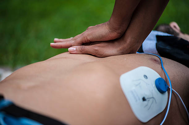 Cardiac massage Resuscitation on a gauy in the park defibrillator photos stock pictures, royalty-free photos & images