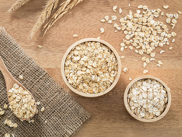 istock Wheat flakes and barley flake in wooden bowl 614707882