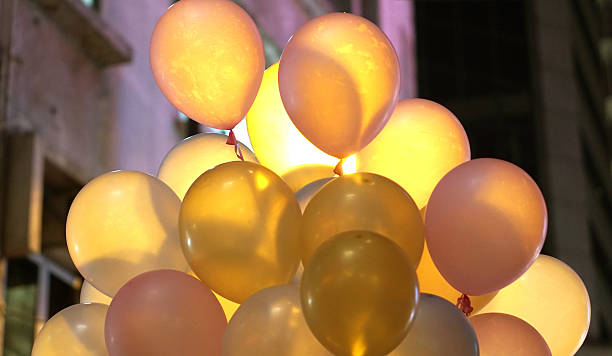 istock Colourful in town party balloons at night with back light 614710098