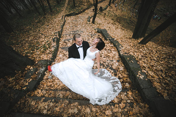 istock groom holds bride in his arms 614711092