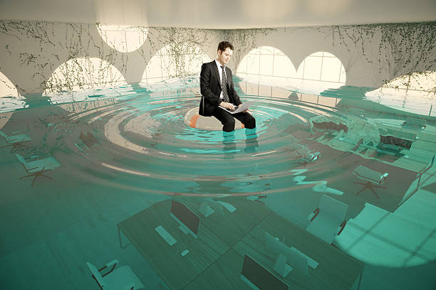 istock Businessman in flooded office 614711818