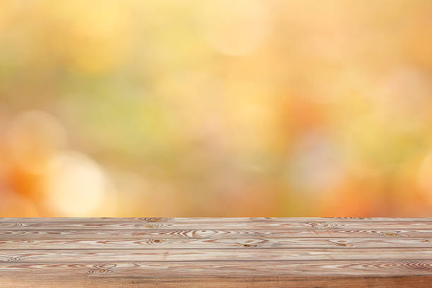 istock Blank wooden table on blurred golden background. 614713730