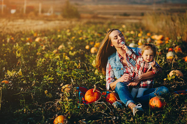 istock mother and daughter on a field with pumpkins 614714656