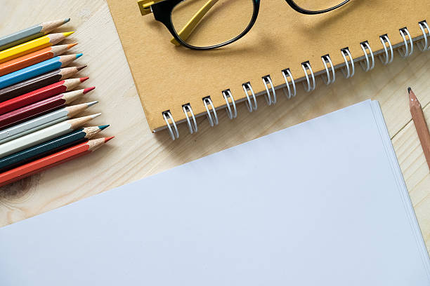 istock blank paper and colorful pencils and glasses 614717406