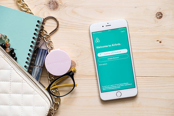 apple iphone 6s plus with airbnb application on the screen. - telephone application software editorial symbol imagens e fotografias de stock