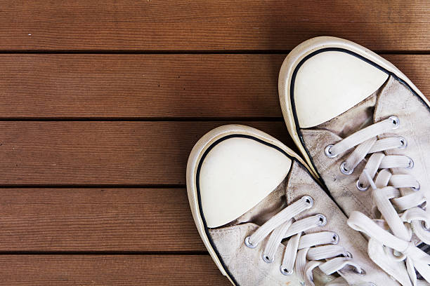 istock Old canvas shoes on a wooden floor 614719112