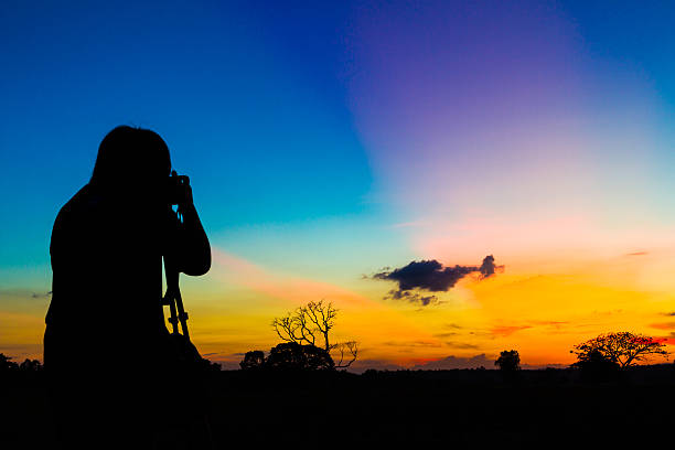 istock Silhouette photographer with sunset 614720380