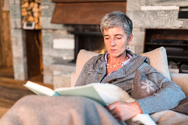 istock woman reading a book on the couch 614721066
