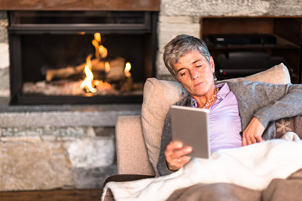 istock woman reading a tablet on the couch 614721148