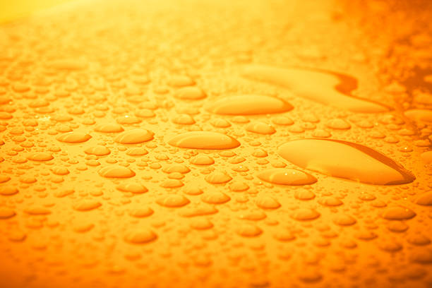 Water drops on orange background. Full frame photo.