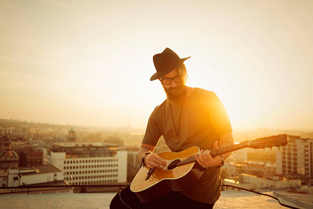 istock musician playing guitar on the roof 614722136