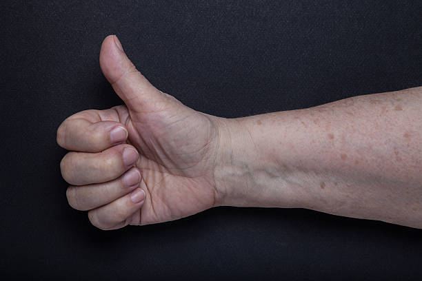 istock Hands of elderly woman on black background 614722812