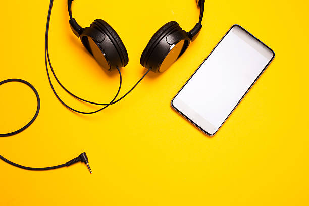 istock Headphones and smart pnone on yellowl bakground 614724006