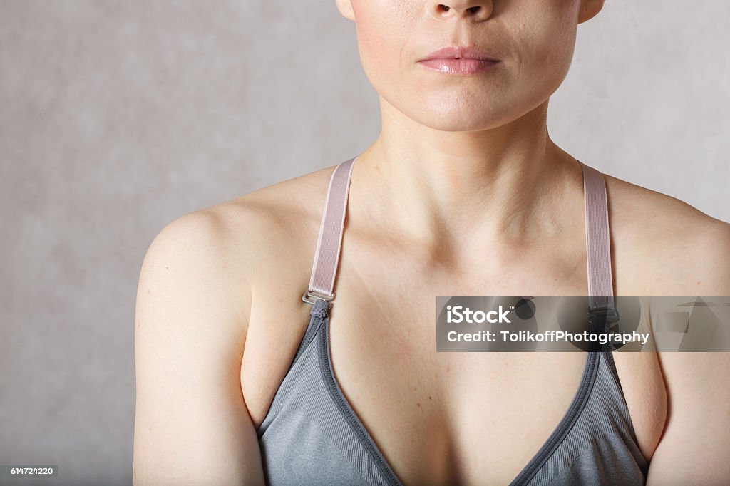 Underarm fat at young woman. Closeup Armpit fat at young woman between 30 and 40 years old dressed in a sporty gray bra. 30-34 Years Stock Photo