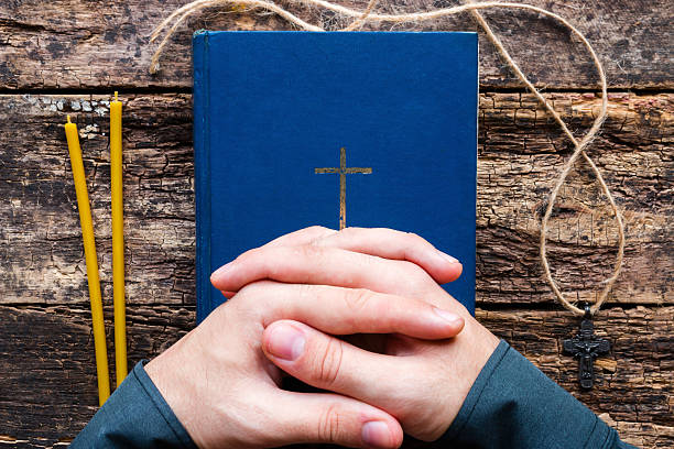 istock man praying on the bible 614726764