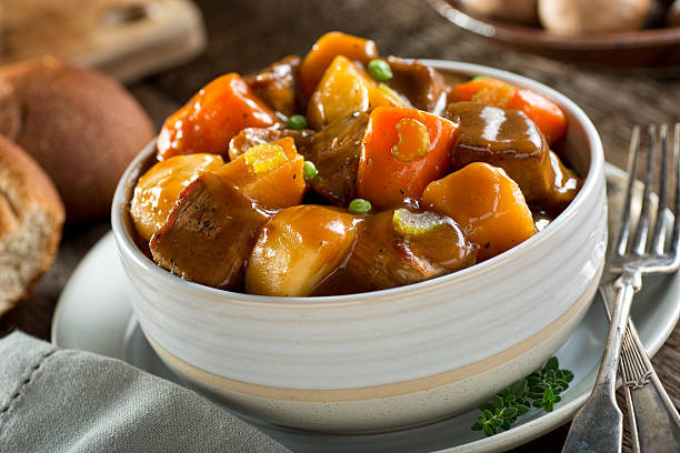 Beef Stew A delicious bowl of rich and hearty beef stew with potato, turnip, carrot, celery, and peas. beef stew stock pictures, royalty-free photos & images