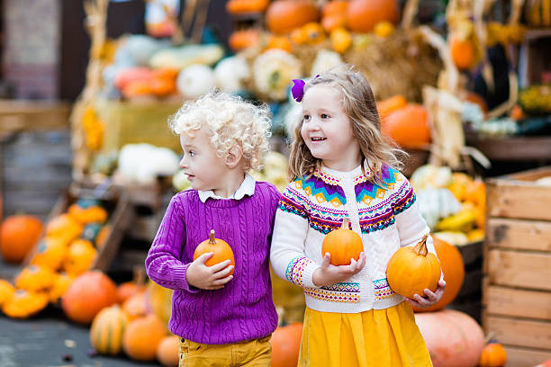 istock Kids having fun harvest festival celebration at pumpkin patch 614731966