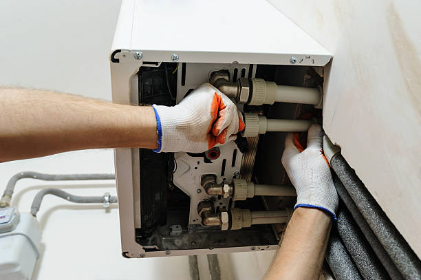 Installation of home heating. Installation of home heating. A worker attaches the pipe to the gas boiler. electric heater stock pictures, royalty-free photos & images