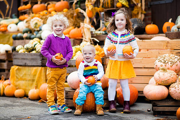 istock Kids having fun at pumpkin patch at  harvest festival celebration 614732818