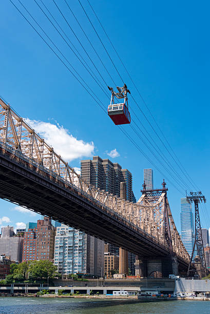 New York City cable car Overhead cable car next to the Queensboro Bridge over the East River in New York City to Roosevelt Island. roosevelt island stock pictures, royalty-free photos & images