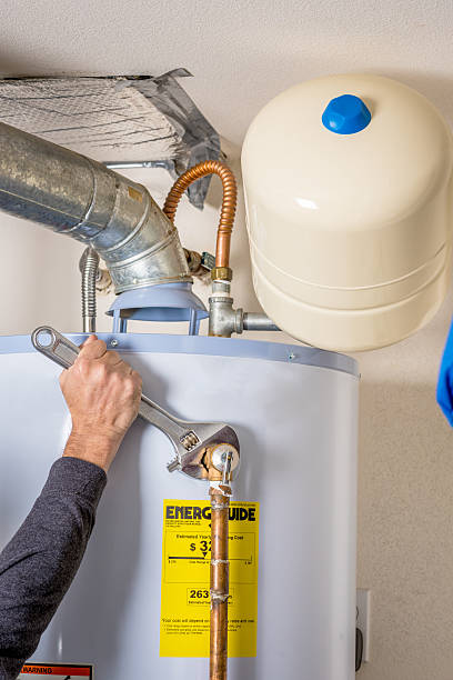 istock Hot water heater maintenance with a wrench 614737324