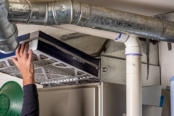 Man replaces a filter in a furnace stock photo