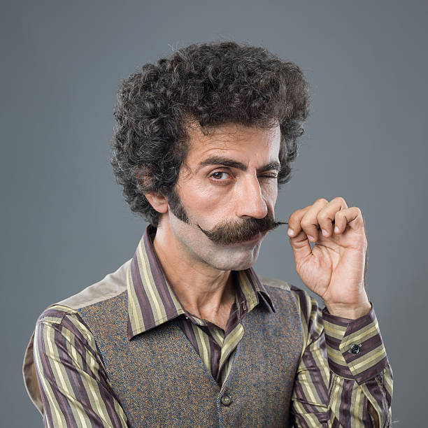 Winking adult man curling up his handle bar mustache stock photo
