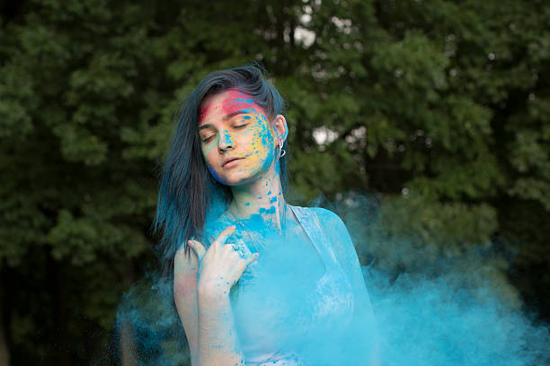 istock Brunette woman with colored powder around her 614739876