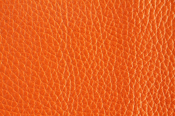 istock Orange colored cow leather texture. Closeup. Macro 614740454