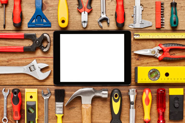 istock Digital tablet and various hand tools arranged on wooden floor 614745914