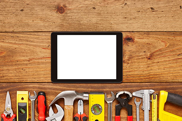 istock Digital tablet with various hand tools on wooden floor 614746612