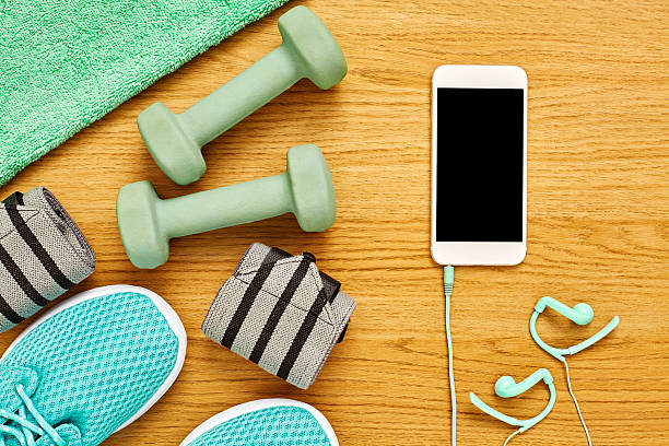 istock Flat lay of exercise equipment with smart phone on wood 614747450
