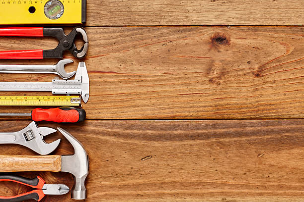 istock Various work tools on left side of wooden floor 614747618