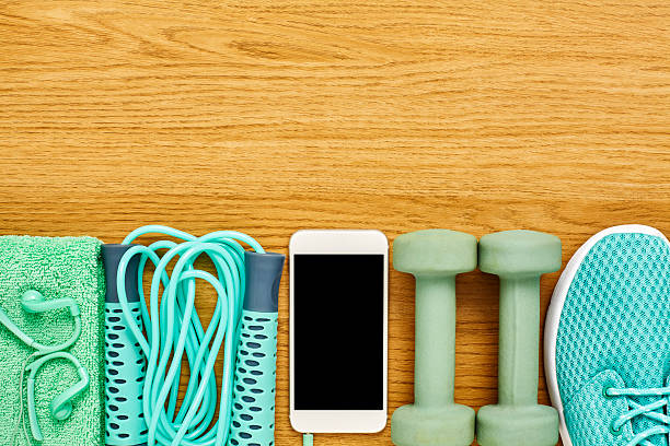 istock Flat lay of exercise equipment with smart phone on wood 614748720