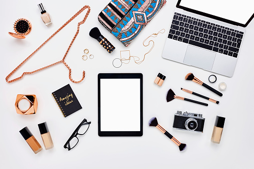 Flat lay of beauty products and accessoroes on bloggers desk