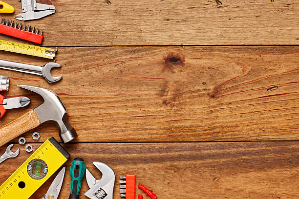 istock Various construction tools on left side of wooden floor 614749316