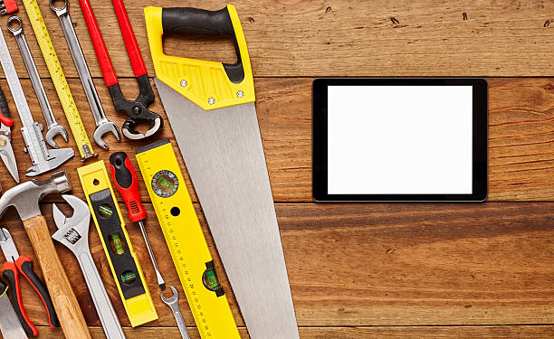 istock Digital tablet with various hand tools on wooden floor 614832272