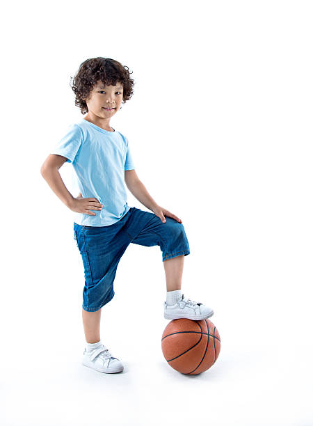 istock Young boy with a basketball against white background 614833182
