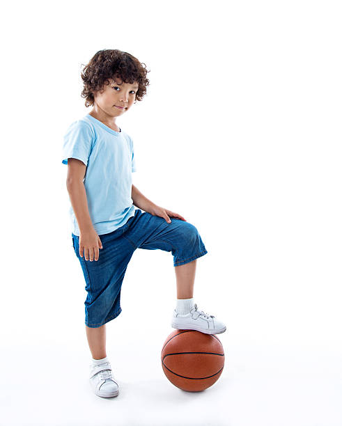 istock Young boy with a basketball against white background 614833294