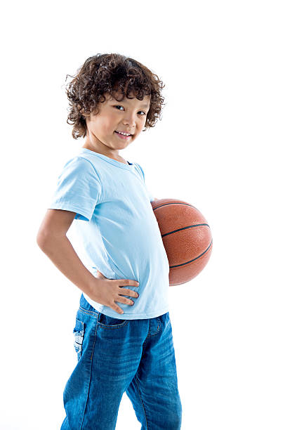 Young boy holding a basketball against white background