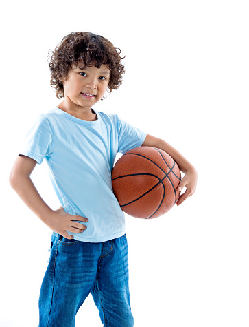 Young boy holding a basketball against white background.