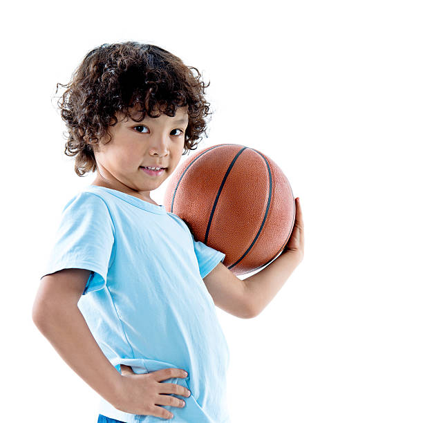 istock Young boy holding a basketball against white background 614833890