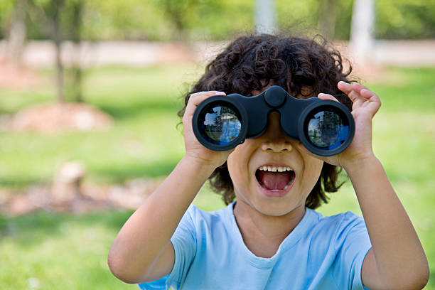 маленький мальчик, держащий бинокль в парке - little boys discovery binoculars child стоковые фото и изображения