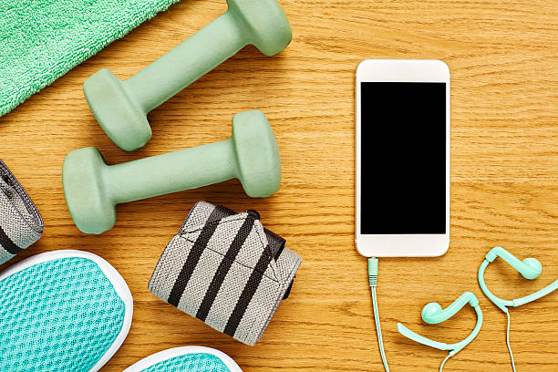istock Exercise equipment with smart phone on hardwood floor 614835086