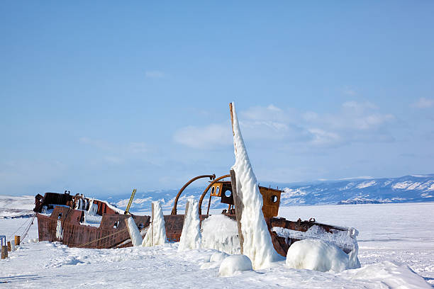 vieux navire gelé sur la rive de l’île d’olkhon en sibérie - scow photos et images de collection