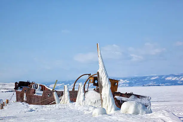 Old frozen castaway ship on the bank of Olkhon island on siberian lake Baikal at winter time