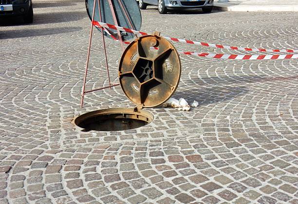 manhole open in the street - segnalazione imagens e fotografias de stock